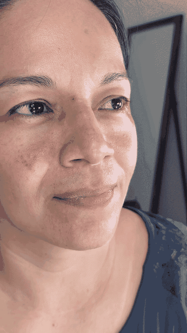 Mujer aplicando poca cantidad sobre un punto de la frente
